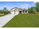 Beautiful house with a well-maintained lawn, two-car garage, and inviting facade at 16043 Penn State Rd, Weeki Wachee, FL 34614