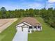 New construction home with a three car garage, craftsman-style details, and a well maintained lawn at 16043 Penn State Rd, Weeki Wachee, FL 34614