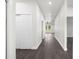A long hallway featuring dark wood flooring and access to multiple rooms at 16043 Penn State Rd, Weeki Wachee, FL 34614