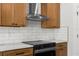 Well-equipped kitchen features stainless steel range hood, electric stove, and ample wood cabinetry at 16043 Penn State Rd, Weeki Wachee, FL 34614