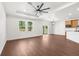 Light filled living space with wood flooring, bright white walls, and large windows offering wooded views at 16043 Penn State Rd, Weeki Wachee, FL 34614