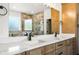 Modern bathroom featuring double sinks with marble countertop and frameless shower with elegant stone tile at 16043 Penn State Rd, Weeki Wachee, FL 34614