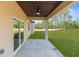Covered patio with ceiling fan, offering a view of the backyard and surrounding trees at 16043 Penn State Rd, Weeki Wachee, FL 34614