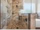 This luxurious shower features stone walls, pebble flooring and a sleek glass enclosure at 16043 Penn State Rd, Weeki Wachee, FL 34614