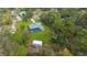 Overhead aerial view of property featuring the home, pool, lush greenery, and additional storage shed at 16386 Heron Hills Dr, Spring Hill, FL 34610