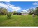 Spacious backyard view featuring screened-in pool area and lush green lawn at 16386 Heron Hills Dr, Spring Hill, FL 34610