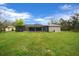 Backyard showcasing lush lawn and a screened-in pool area at 16386 Heron Hills Dr, Spring Hill, FL 34610