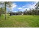 Backyard showcasing lush lawn and a screened in pool area at 16386 Heron Hills Dr, Spring Hill, FL 34610