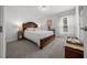 A serene bedroom with a large wooden bed frame, soft carpet, and natural light from the window at 16386 Heron Hills Dr, Spring Hill, FL 34610