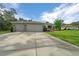 Charming home featuring a three-car garage, well-maintained landscaping, and a welcoming front entrance at 16386 Heron Hills Dr, Spring Hill, FL 34610