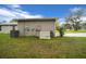 Exterior home view showcasing generator and utilities against a lush backyard backdrop at 16386 Heron Hills Dr, Spring Hill, FL 34610