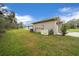 Exterior home view showcasing generator and utilities against a lush backyard backdrop at 16386 Heron Hills Dr, Spring Hill, FL 34610