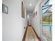 Bright hallway featuring hardwood floors, neutral walls, decorative rugs and access to the pool area at 16386 Heron Hills Dr, Spring Hill, FL 34610