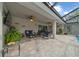 Covered patio featuring a ceiling fan, comfortable seating area, and a large TV for outdoor entertainment at 16386 Heron Hills Dr, Spring Hill, FL 34610