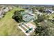 Community aerial view featuring tennis and bocce ball courts, set amongst green lawns and a lake at 18045 Tarrington Pl, Hudson, FL 34667