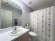 Cozy bathroom showcasing a neutral color scheme, single sink vanity, and a shower with a decorative curtain at 18045 Tarrington Pl, Hudson, FL 34667