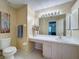 Well-lit bathroom featuring a vanity with ample counter space, toilet, and neutral decor at 18045 Tarrington Pl, Hudson, FL 34667