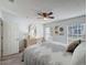 Airy bedroom with a ceiling fan, natural light from two windows, and a plush queen bed at 18045 Tarrington Pl, Hudson, FL 34667