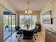 Inviting breakfast nook with slider to lanai, a chandelier, and lots of natural light at 18045 Tarrington Pl, Hudson, FL 34667