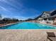 Large community pool with brick surround and ample lounge seating for residents at 18045 Tarrington Pl, Hudson, FL 34667