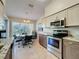 Bright eat-in kitchen featuring stainless steel appliances, granite counters, and large windows at 18045 Tarrington Pl, Hudson, FL 34667
