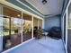 Enclosed lanai with blue accents and glass sliding doors leading to the outdoors at 18045 Tarrington Pl, Hudson, FL 34667