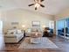 Bright living room with a vaulted ceiling, ceiling fan, wood floors, and sliding glass doors at 18045 Tarrington Pl, Hudson, FL 34667