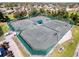 Aerial view of well-maintained tennis courts surrounded by trees in a desirable neighborhood at 18045 Tarrington Pl, Hudson, FL 34667