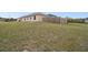 Spacious, grassy backyard features a fence and distant neighbor's homes at 18317 Treehaven Dr, Hudson, FL 34667