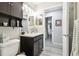 A well-lit bathroom features a vanity, mirror, and view into the hallway at 18317 Treehaven Dr, Hudson, FL 34667