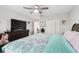 Well-lit bedroom with gray walls, ceiling fan, large television, and ample closet space at 18317 Treehaven Dr, Hudson, FL 34667
