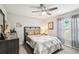 Cozy bedroom with hardwood floors, ceiling fan, and large windows for natural light at 18317 Treehaven Dr, Hudson, FL 34667