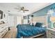 Comfortable bedroom features a ceiling fan, white furniture, and a beautiful accent wall at 18317 Treehaven Dr, Hudson, FL 34667