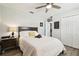 Bedroom features a bed, ceiling fan, closet, and nightstand with a lamp at 18317 Treehaven Dr, Hudson, FL 34667
