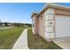 Charming house exterior with stucco walls, a two-car garage, and a well-kept lawn under a clear sky at 18317 Treehaven Dr, Hudson, FL 34667