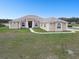 Expansive single story home featuring a large yard, neutral stucco exterior, and a columned front entry at 18317 Treehaven Dr, Hudson, FL 34667
