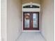 Up close view of front door featuring glass paned double doors and decorative wreath at 18317 Treehaven Dr, Hudson, FL 34667