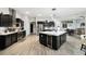 Modern kitchen featuring sleek black cabinets, a large island, and stainless steel appliances at 18317 Treehaven Dr, Hudson, FL 34667