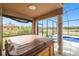 Enjoy outdoor living on this lanai with a hot tub and view of the pool and lake at 18317 Treehaven Dr, Hudson, FL 34667