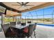 Enclosed patio with view of pool and lake featuring a table with six bar stools at 18317 Treehaven Dr, Hudson, FL 34667