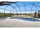 Screened-in pool with adjacent patio and lake view at 18317 Treehaven Dr, Hudson, FL 34667