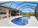 Screened-in kidney shaped pool with patio and view of neighboring house at 18317 Treehaven Dr, Hudson, FL 34667