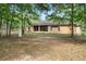 Back of house with screened porch and lush lawn with mature trees at 19263 Quiet Oak Ln, Brooksville, FL 34604