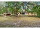 Exterior of stucco house with screened in porch in wooded backyard at 19263 Quiet Oak Ln, Brooksville, FL 34604