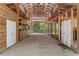 Interior of barn with multiple stalls and large open area with concrete floor at 19263 Quiet Oak Ln, Brooksville, FL 34604