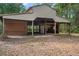 Side view of large barn with tan metal siding and wood accents at 19263 Quiet Oak Ln, Brooksville, FL 34604