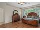 Comfortable bedroom featuring wood floors, a decorative dresser and a cozy bed at 19263 Quiet Oak Ln, Brooksville, FL 34604