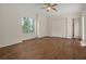 Bedroom showcasing wood-style tile flooring, a ceiling fan, large windows, and a closet at 19263 Quiet Oak Ln, Brooksville, FL 34604