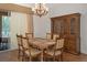 Formal dining room with wood table, chairs, wood floors, and china cabinet with lighting at 19263 Quiet Oak Ln, Brooksville, FL 34604