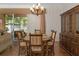 Traditional dining room featuring a wooden table, ornate chandelier, and built-in china cabinet at 19263 Quiet Oak Ln, Brooksville, FL 34604